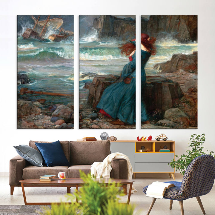 The Miranda by the Shore Wall Art Canvas Print depicts a woman in a blue dress standing by the sea, watching a shipwreck.