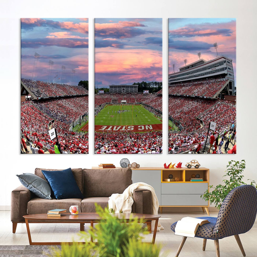 Triple-panel canvas art of Carter-Finley Stadium during an NC State Wolfpack football game, with the crowd and game illuminated by a vibrant sunset.