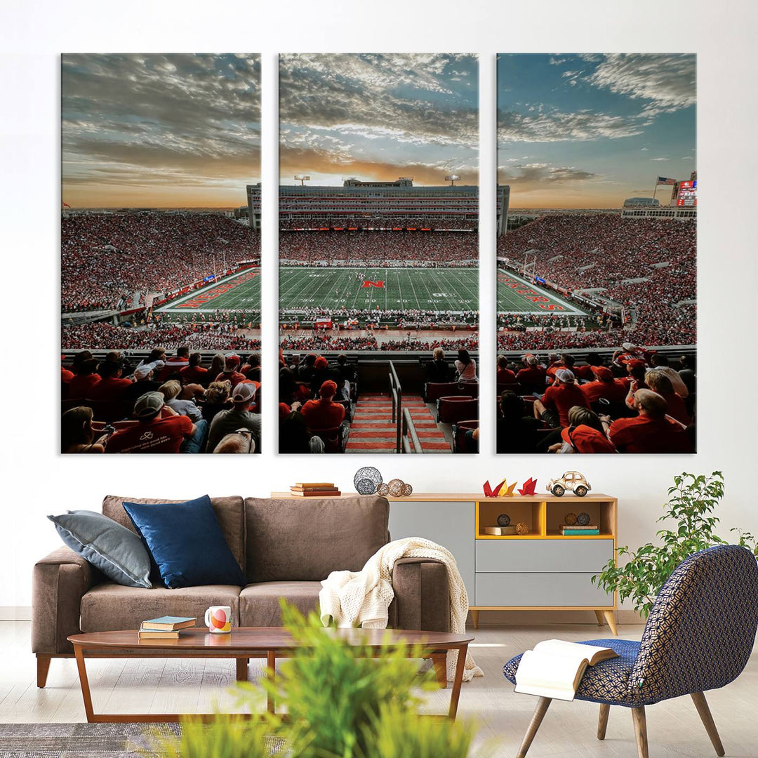 The living room features a stunning triptych of Lincoln Memorial Stadium wall art canvas print, celebrating the University of Nebraska Cornhuskers football team. This piece serves as captivating wall art, showcasing a gallery-quality finish.