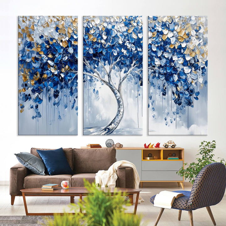 The Blue and Gold Abstract Tree Wall Art showcases a swirl trunk and features blue, silver, and gold leaves on a framed canvas print.