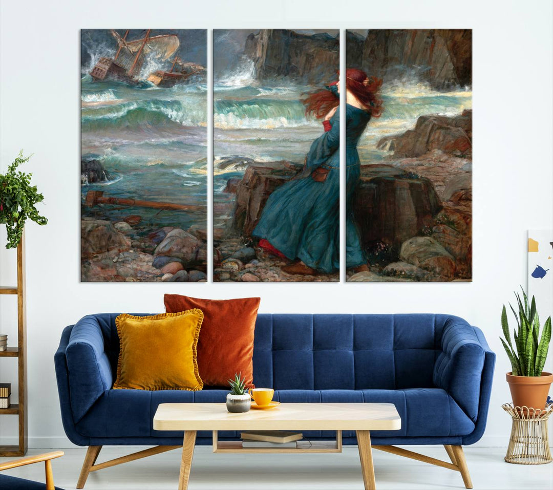 The Miranda by the Shore Wall Art Canvas Print depicts a woman in a blue dress standing by the sea, watching a shipwreck.