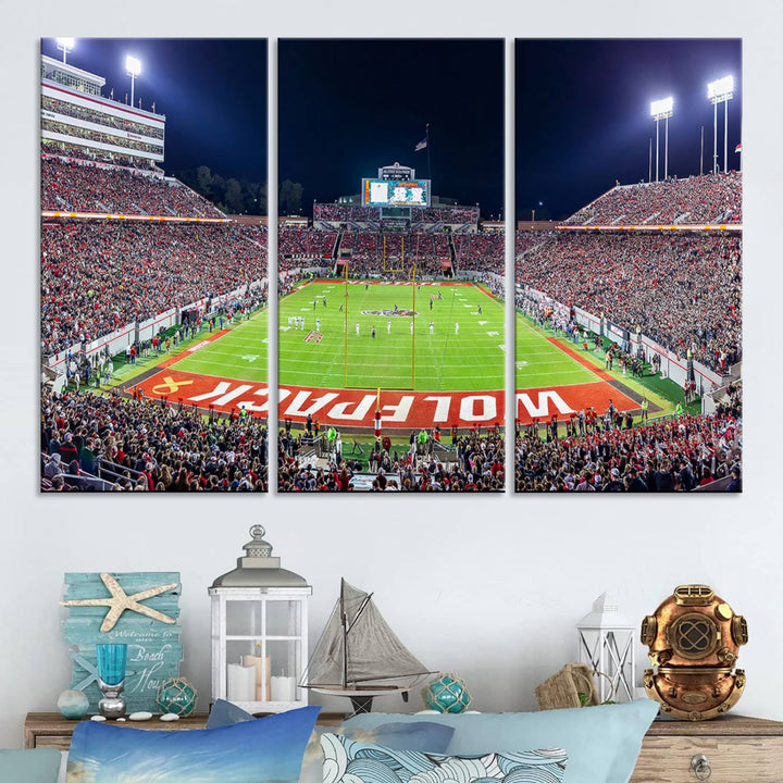 A NC State Wolfpack Football Team print of Carter-Finley Stadium at night features WOLFPACK illuminated brightly in the end zone grass.