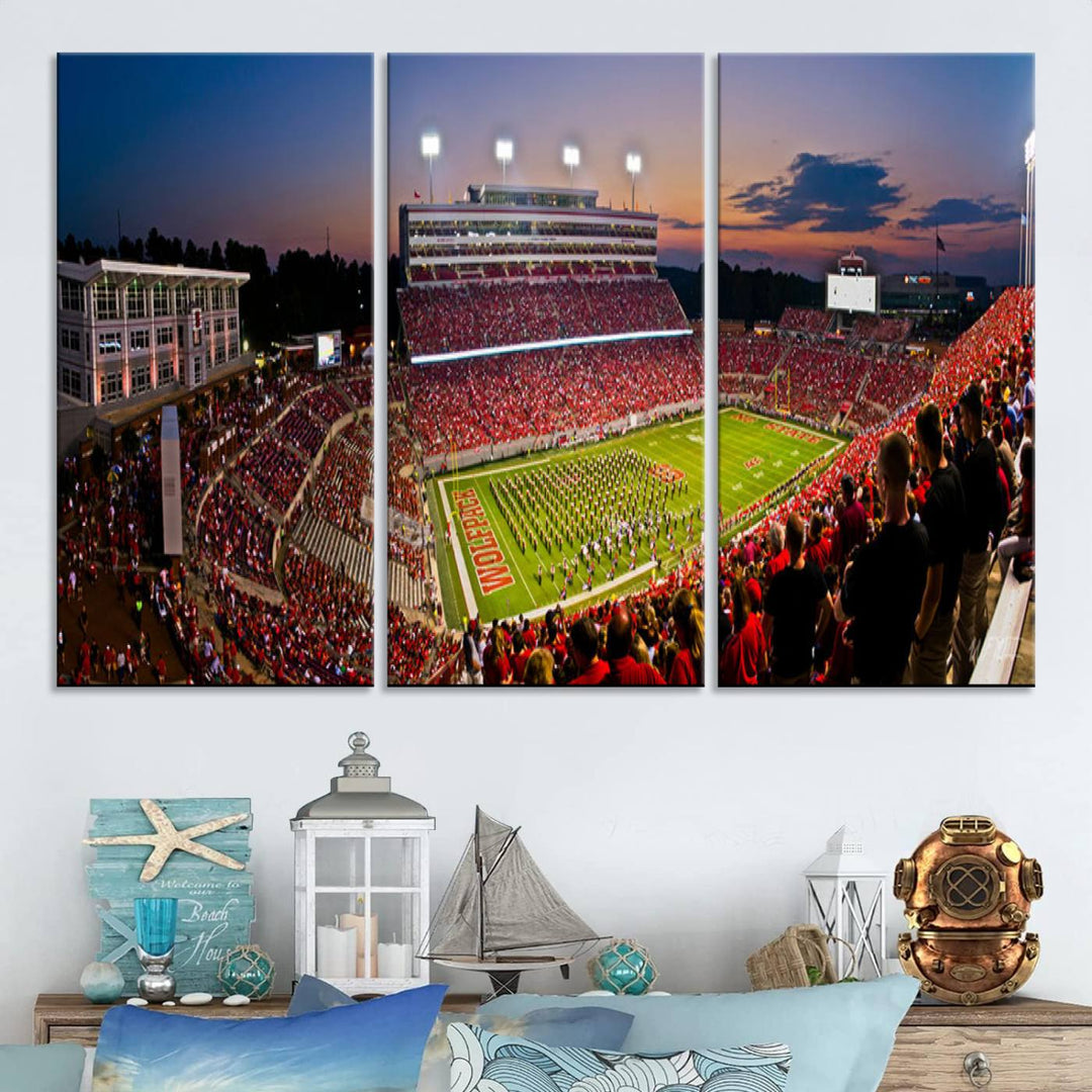 A print of a bustling Carter-Finley Stadium at dusk, featuring fans and a band, captures the essence of NC State Wolfpack football.