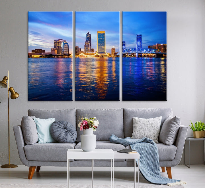 A cozy living room features the Jacksonville Wall Art Canvas Print, a large triptych crafted on museum-quality canvas that beautifully depicts the Jacksonville city skyline at sunset.