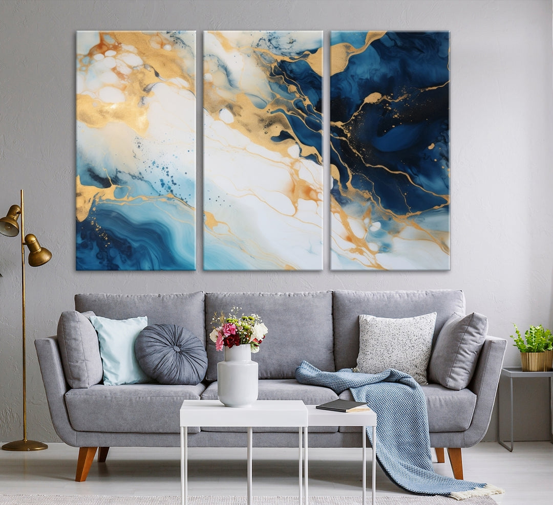 A modern living room featuring museum-quality Blue Gold Abstract Wall Art Print Contemporary art in a triptych arrangement.