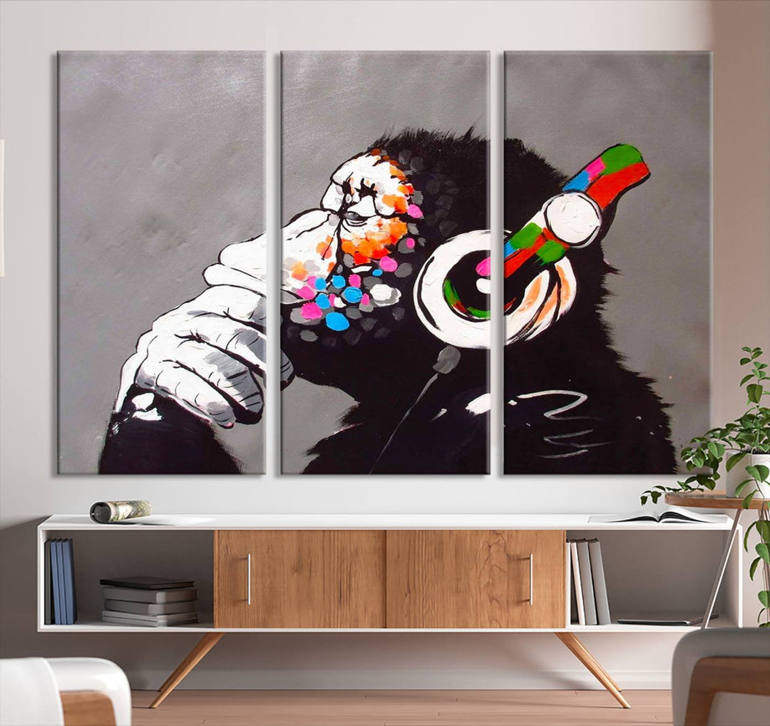 A vibrant triptych, the "DJ Monkey Listening to Music" wall art print, features a Banksy-inspired large canvas adorned with colorful modern pop art. This striking piece elegantly enhances the room with its dynamic and lively depiction.