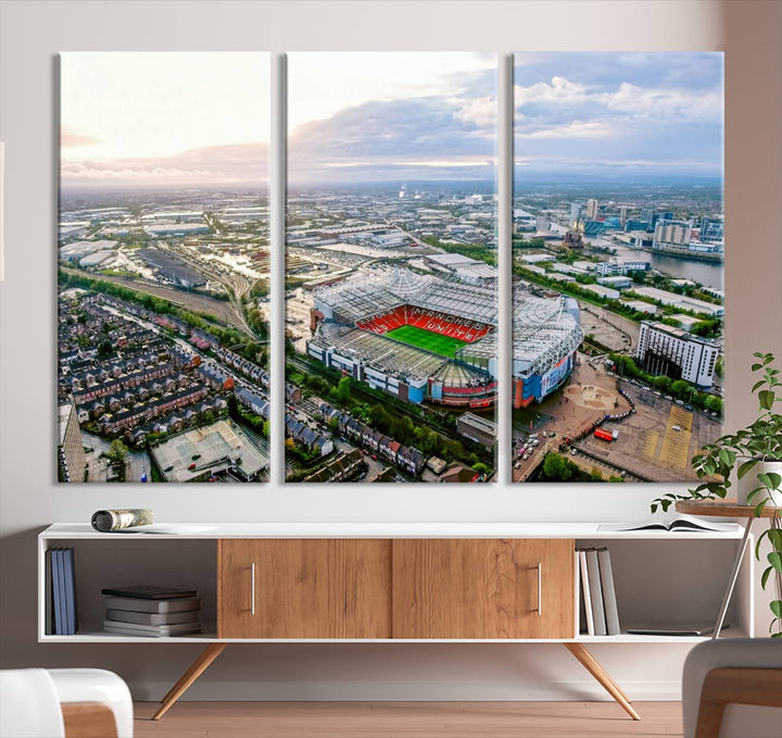 The "Old Trafford Manchester United Stadium Wall Art Canvas Print" adorns the room, showcasing an aerial view of Old Trafford at sunset. This three-panel wall art is perfect for any devoted Manchester United football fan.