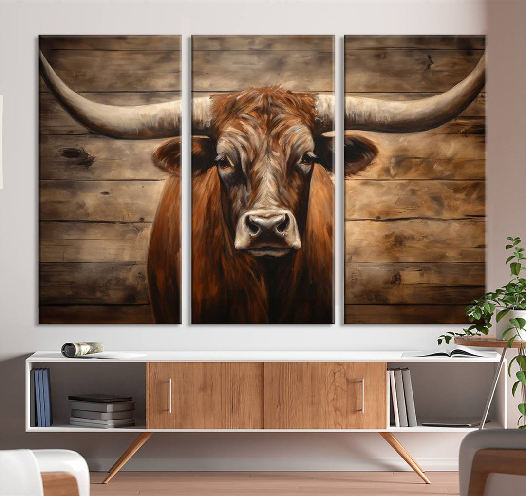 The Longhorn Bull Wall Art, a ready-to-hang canvas print, showcases an image of a brown longhorn cow set against a wooden background, perfect for those looking to enhance their space with rustic farmhouse and western barn decor.