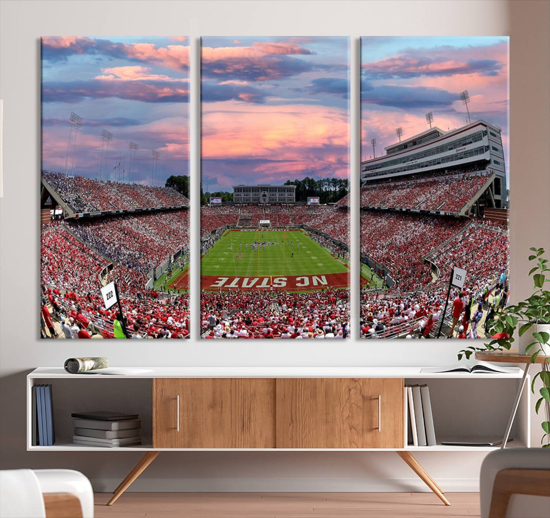 The wall art captures an NC State Wolfpack game under a vibrant sunset on triple canvas.