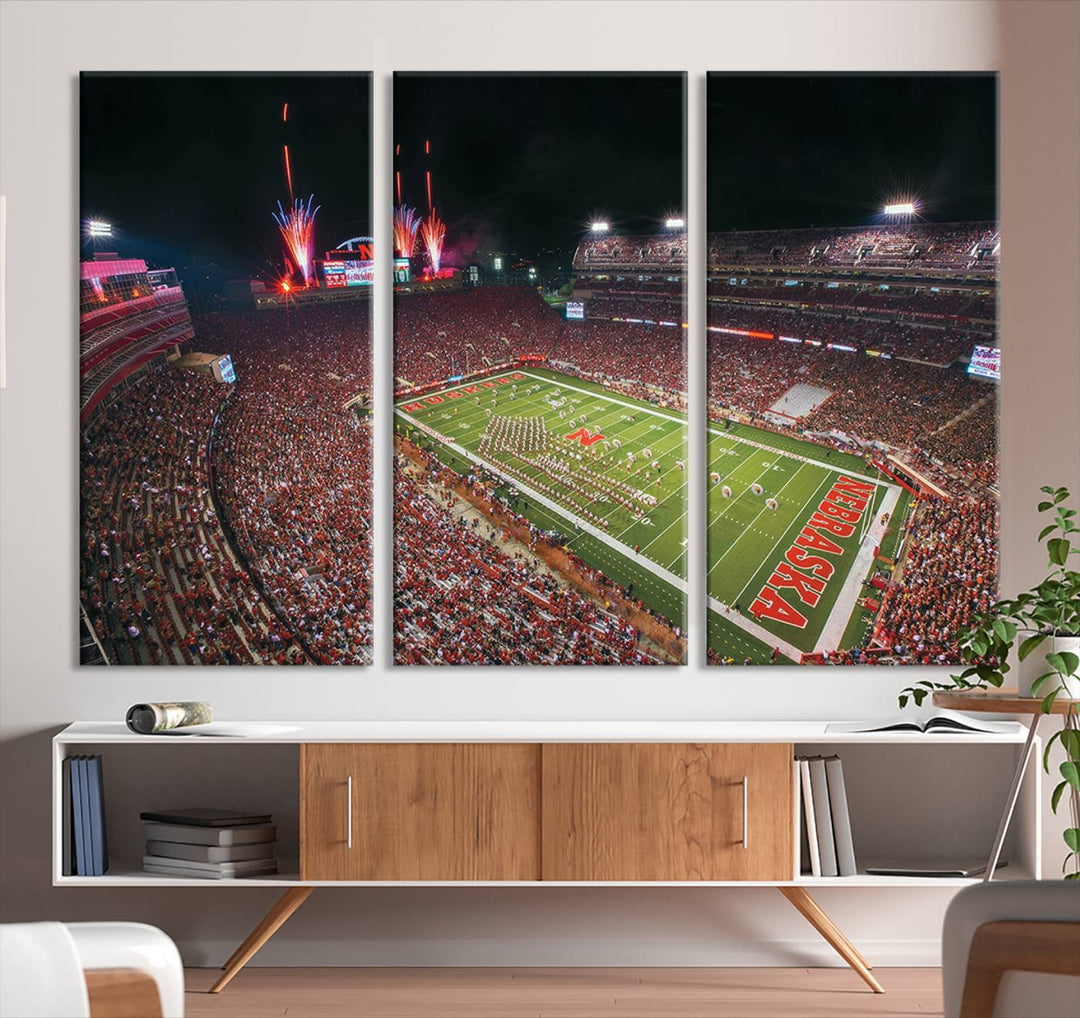 The University of Nebraska Cornhuskers Football Team Print, featuring Lincoln Memorial Stadium in a vibrant triptych canvas with fireworks above and a gallery-quality finish, is elegantly displayed.