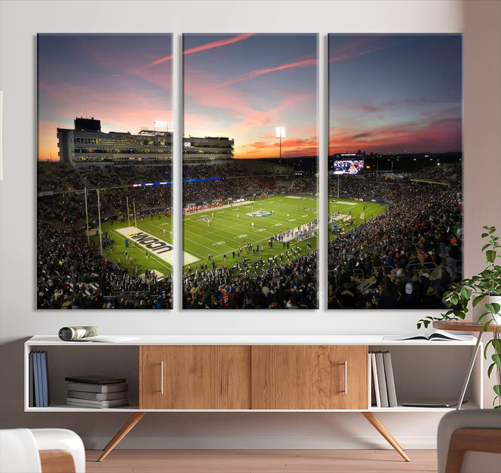 This wall art canvas print captures UCONN Huskies fans energizing a sunset scene at East Hartfords Pratt & Whitney Stadium.