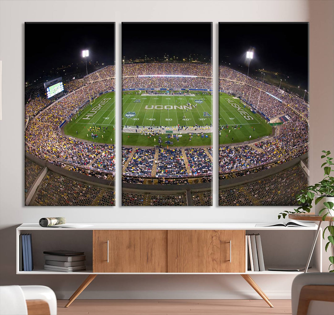 A large football stadium at night, featuring the UCONN Huskies, is depicted on the East Hartford Pratt & Whitney Stadium Wall Art Canvas Print.