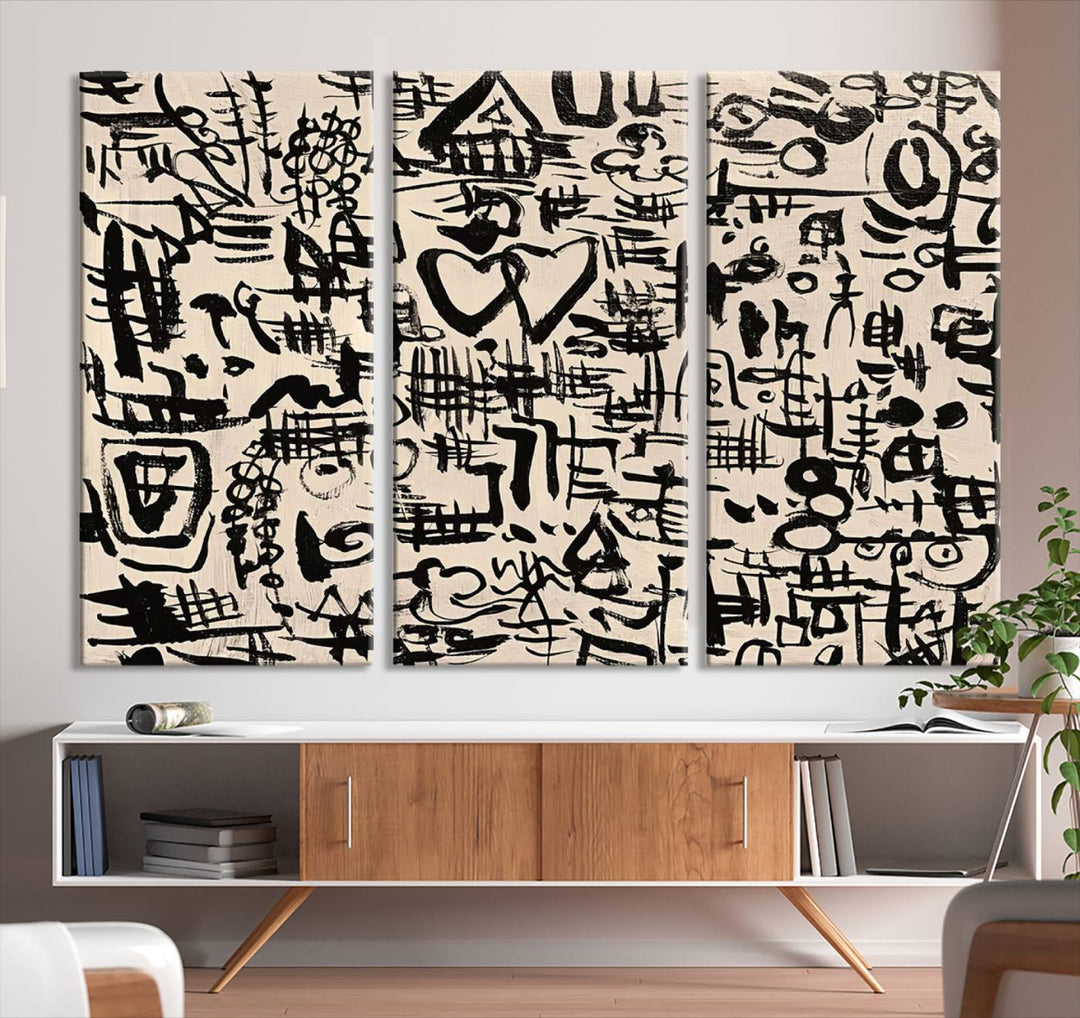 The Abstract Love and Chaos canvas is a museum-quality print featuring black symbols on a beige background, adorned with a heart and scribble design. It is framed to enhance its artistic appeal.