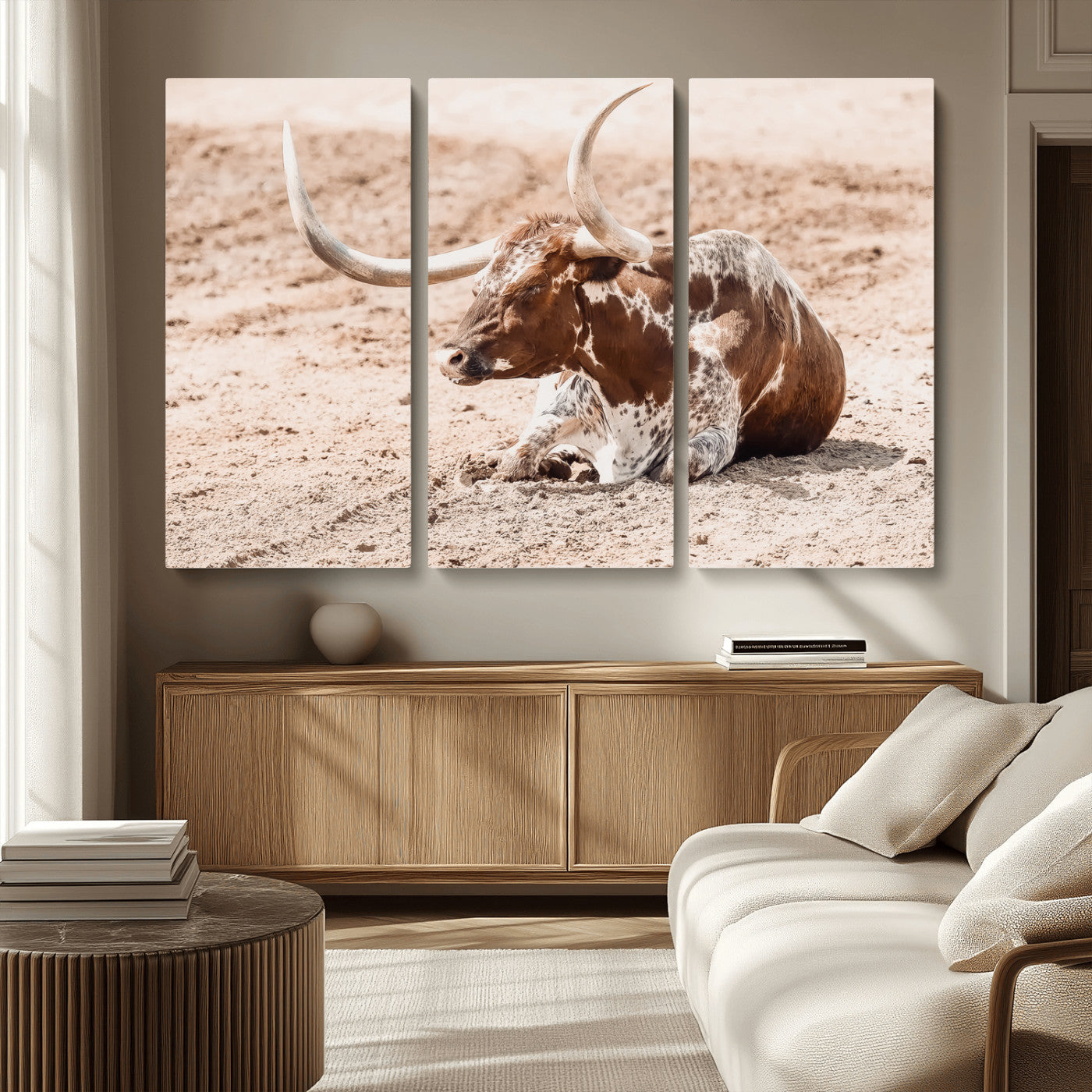 Texas Longhorn bull resting on dusty ground with warm tones, ideal for rustic western or farmhouse-themed wall decor.
