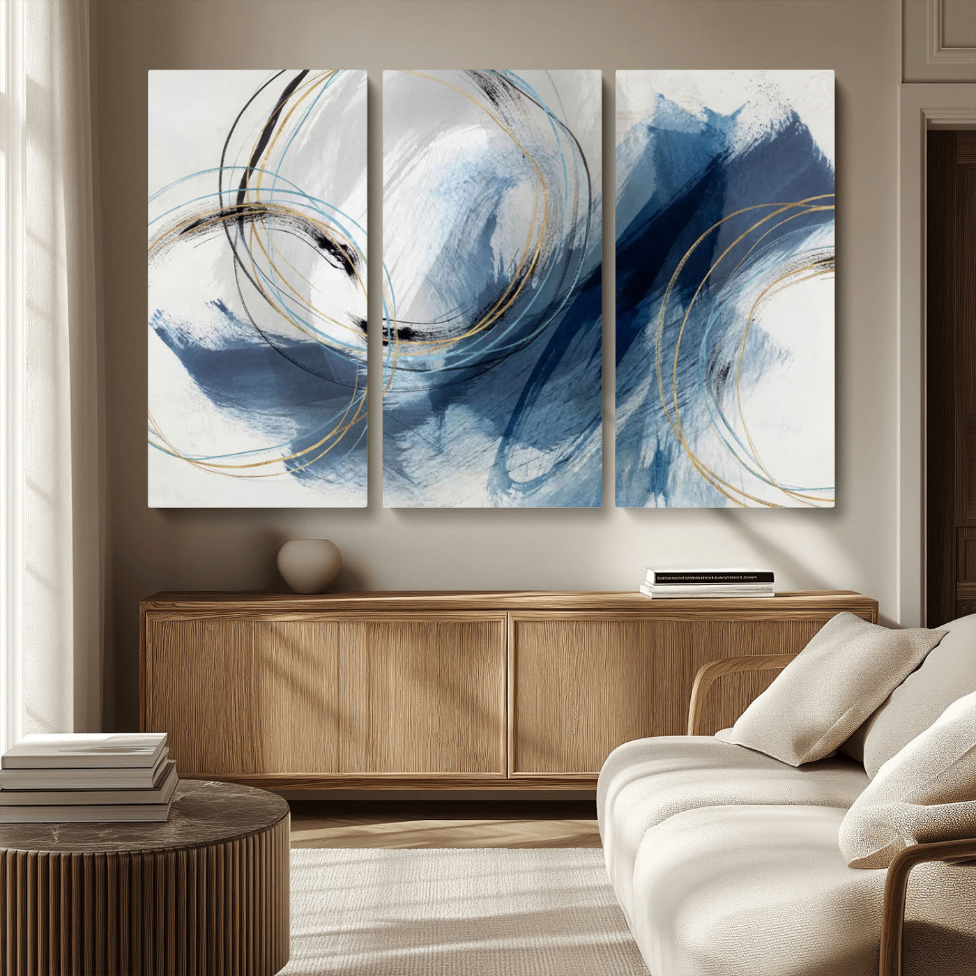 Abstract wall art featuring dynamic brush strokes in shades of blue and gray, overlaid with delicate circular line patterns in gold, black, and light blue on a white background.