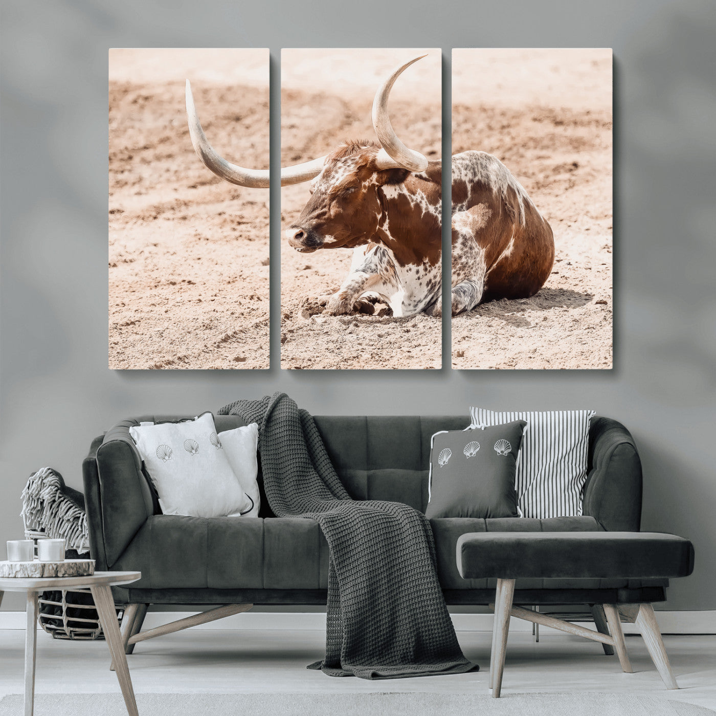 Texas Longhorn bull resting on dusty ground with warm tones, ideal for rustic western or farmhouse-themed wall decor.