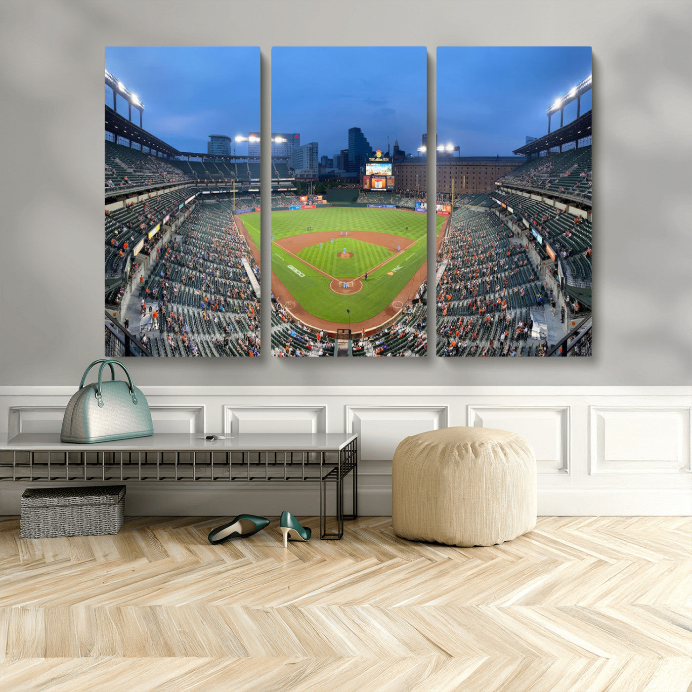 Wide panoramic view of a baseball stadium at dusk with players on the field, stadium lights illuminating the scene, and a sparse crowd of spectators in the stands.