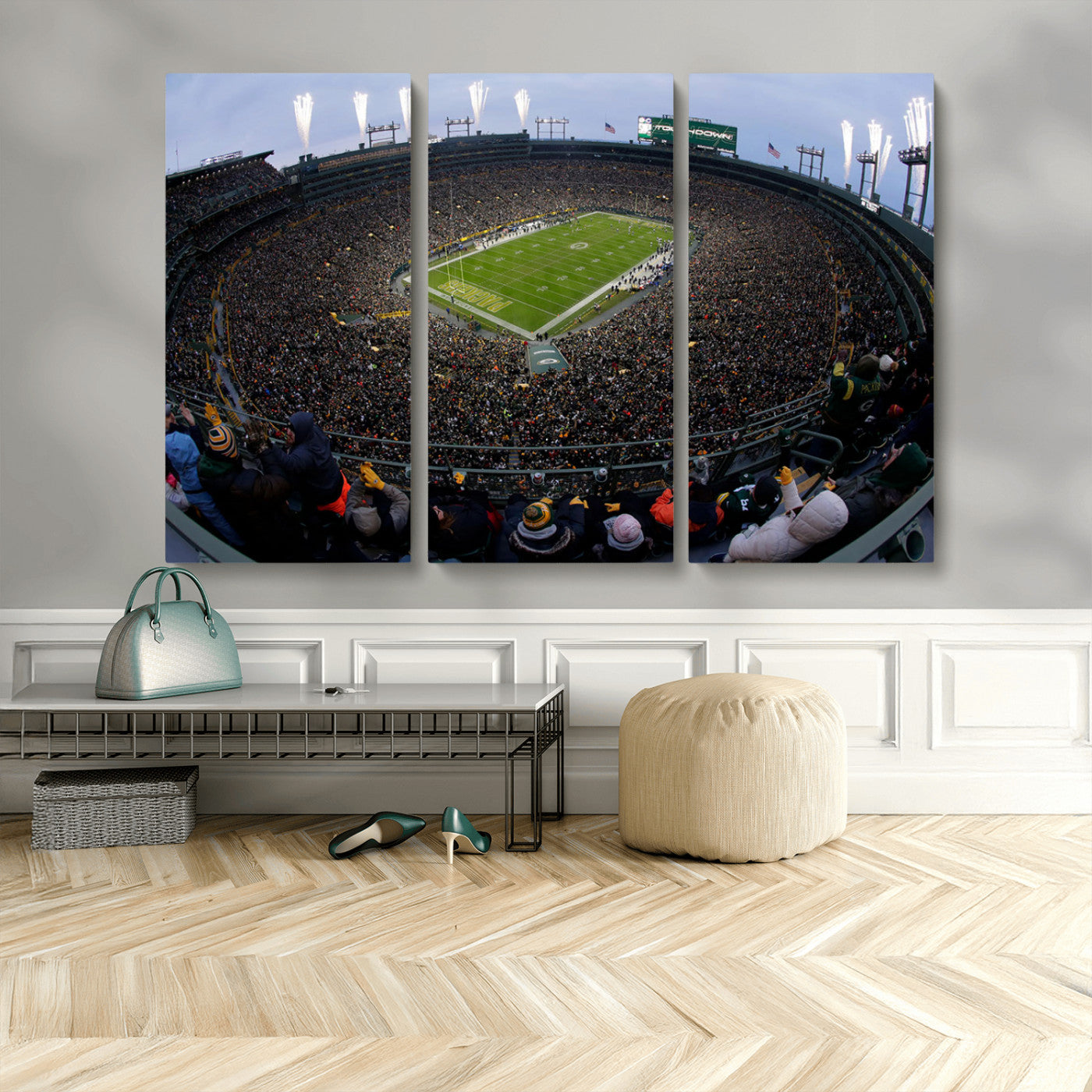 Wide fisheye view of a packed Lambeau Field stadium during an American football game. The crowd fills the stands, and fireworks are going off above the stadium lights. The scoreboard displays "Touchdown," and the field has "Packers" painted in the end zon