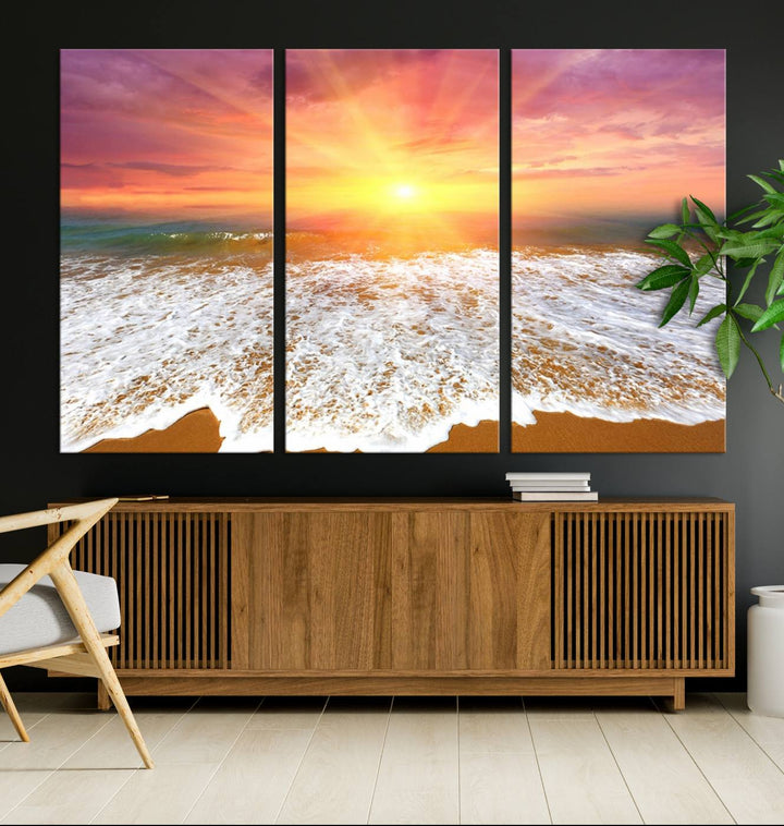 Golden Beach Sunrise 3-panel canvas art of ocean waves, hung on a wooden wall.