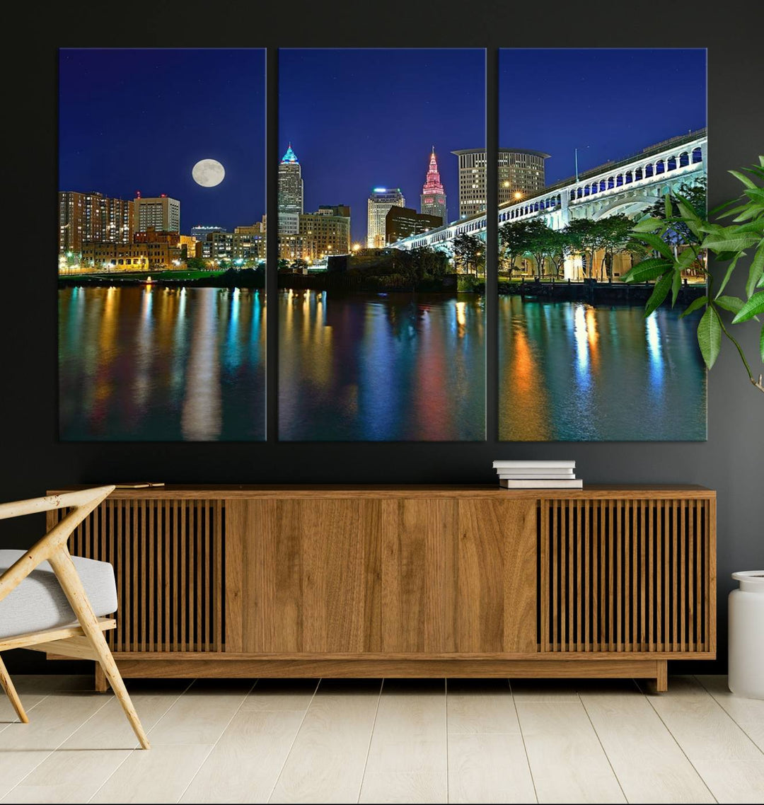 Cleveland City Lights Night Skyline Wall Art canvas showcases a moonlit cityscape reflected on water.