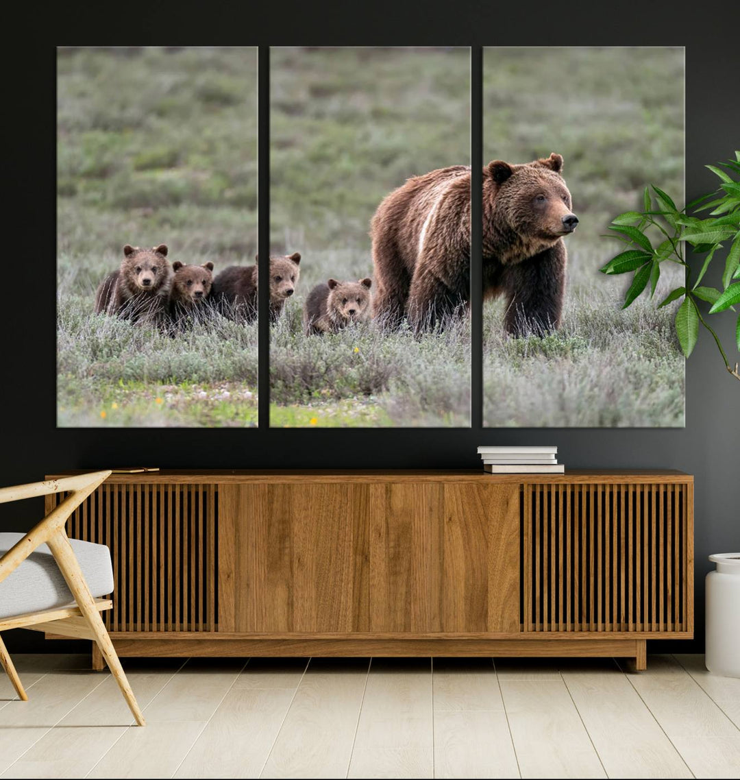 The large canvas print titled "Queen of the Tetons, 399 Grizzly Bear Cubs" showcases majestic wildlife photography of a bear and her cubs walking through the grass. This stunning canvas wall art, handmade in the USA, adds a charming touch to any room with its rustic decor appeal.