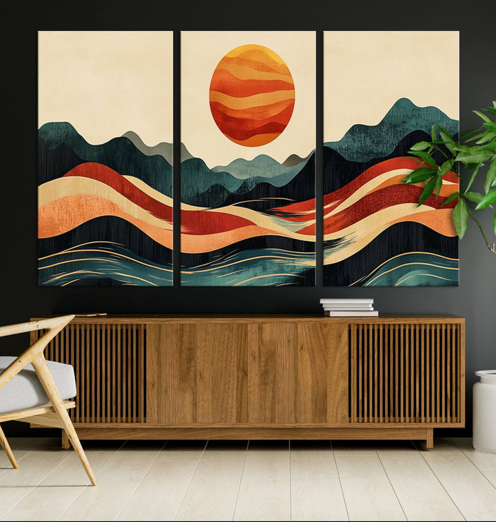 The Mountain Triptych wall art, featuring a design of the sun, mountains, and waves, is displayed prominently on the wall.