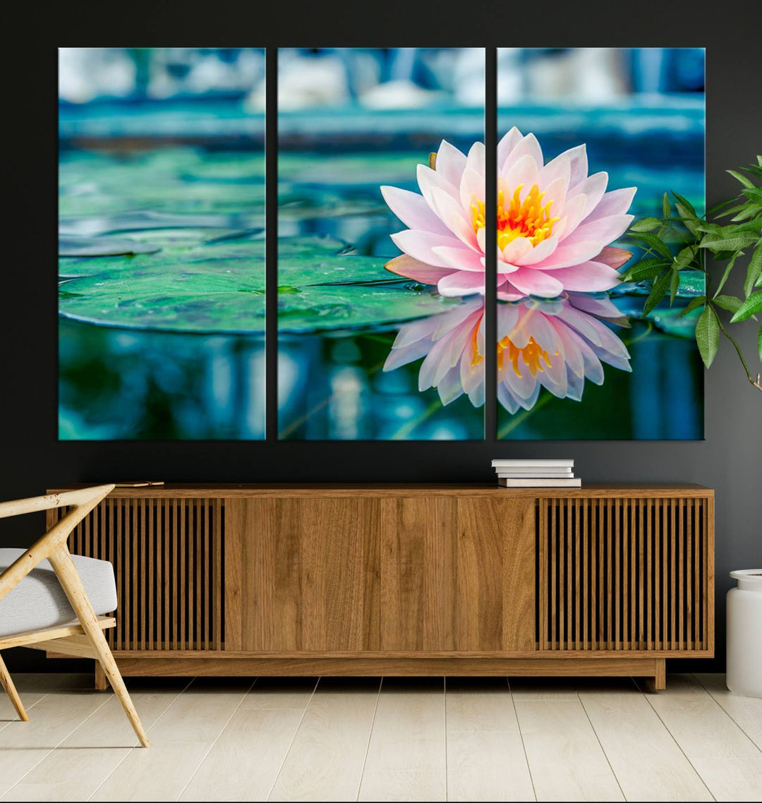 The Lotus Flower Canvas Print showcases a pink water lily with a yellow center gracefully floating on a calm pond.