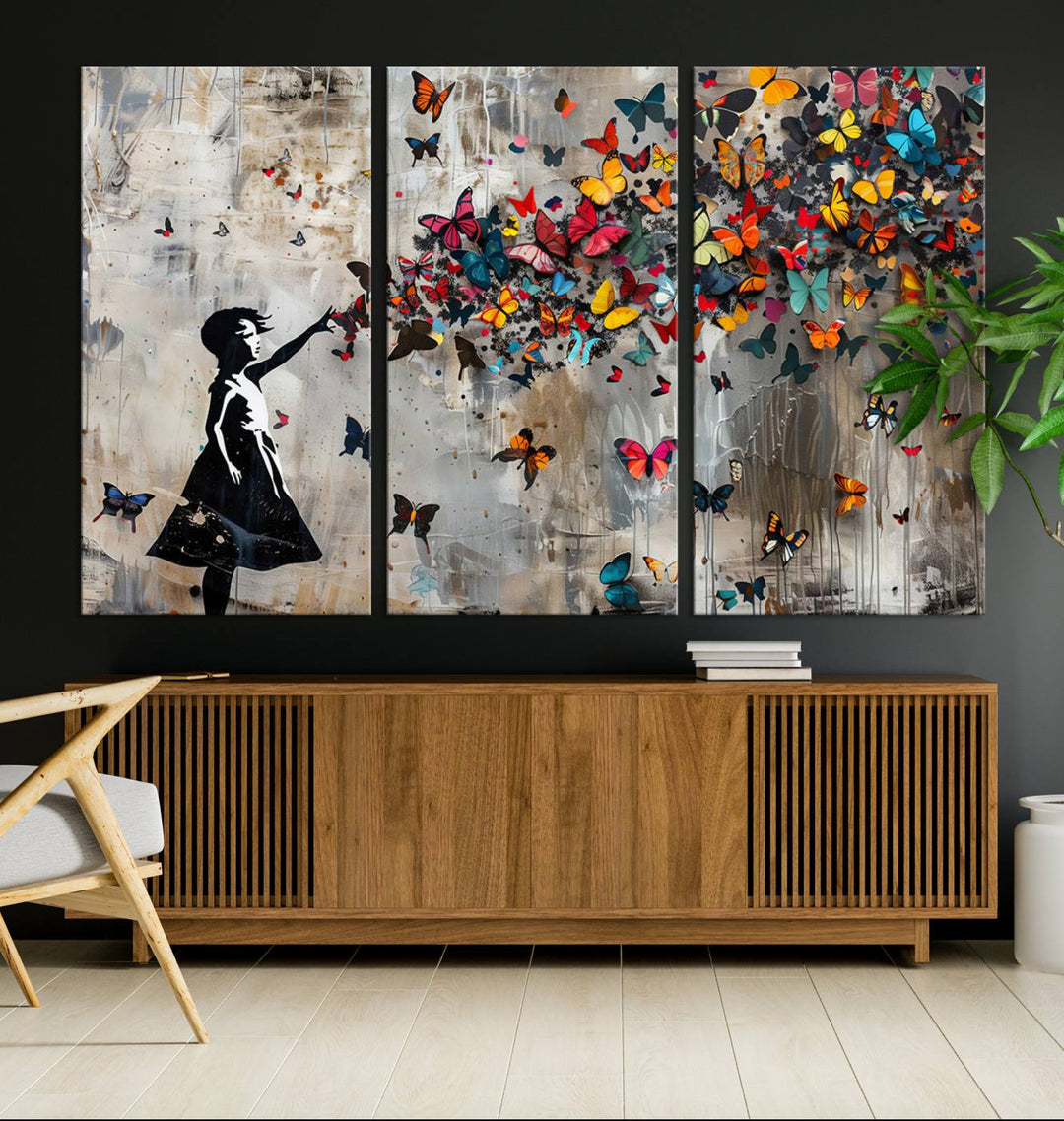 The Banksy Butterfly Girl 3-Piece Modern Graffiti Canvas Wall Art features a silhouette of a girl reaching for butterflies.