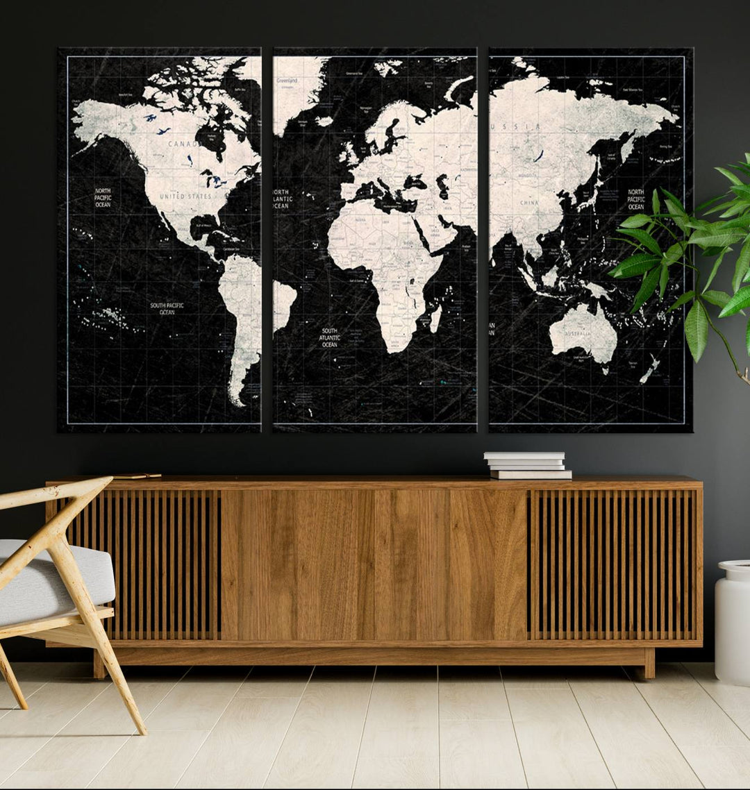 A bold global style framed black and white world map canvas print, presented in three panels, perfect for modern home or office decor.