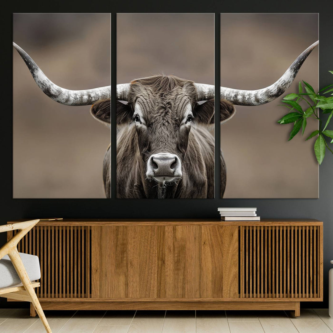 A close-up of a longhorn bull facing forward is featured in the Framed Texas Test-1, set against a blurred brown background.