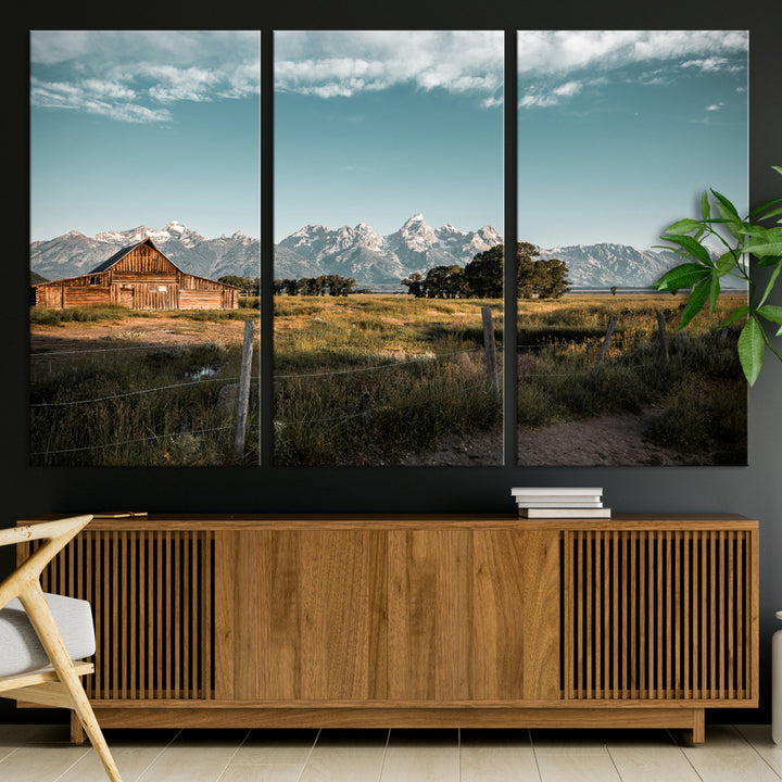 A rustic farmhouse with a wooden barn set against majestic mountain peaks under a soft blue sky, evoking peaceful countryside charm.