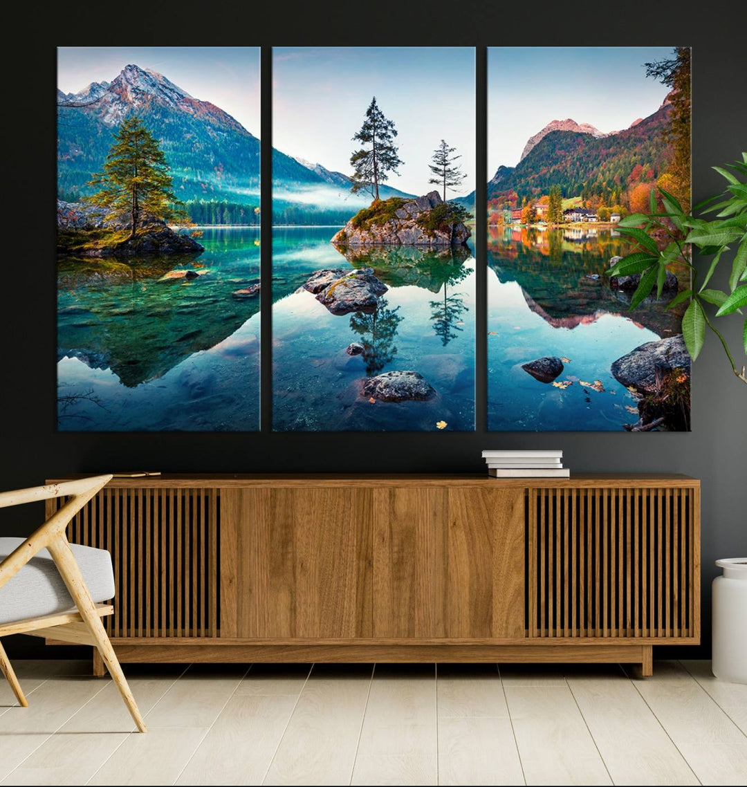 The 3-panel wall art showcases a serene mountain lake with rocky islands and trees, creating an ideal focal point for dining rooms or offices.