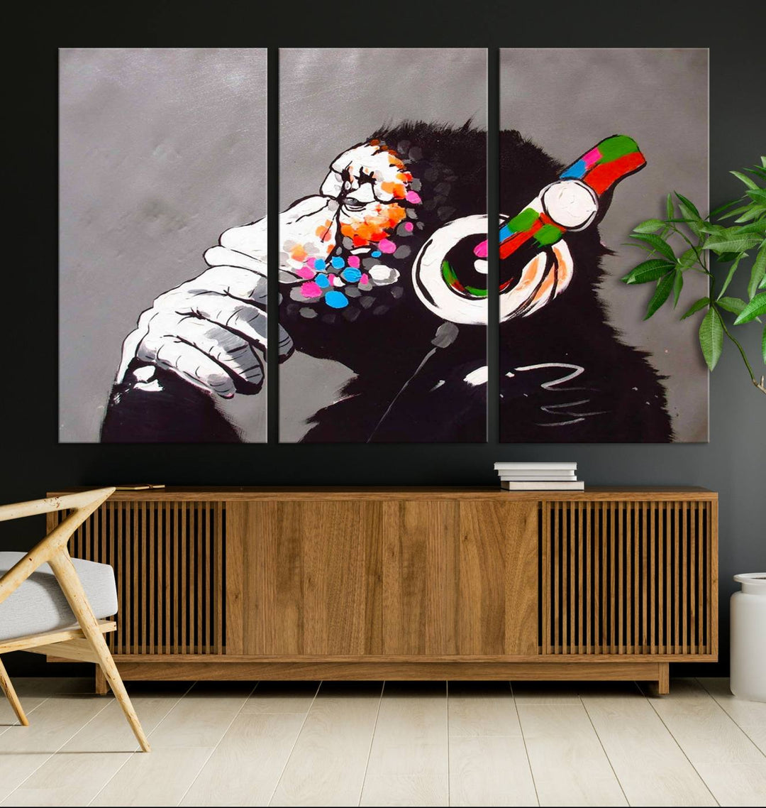 A vibrant triptych, the "DJ Monkey Listening to Music" wall art print, features a Banksy-inspired large canvas adorned with colorful modern pop art. This striking piece elegantly enhances the room with its dynamic and lively depiction.