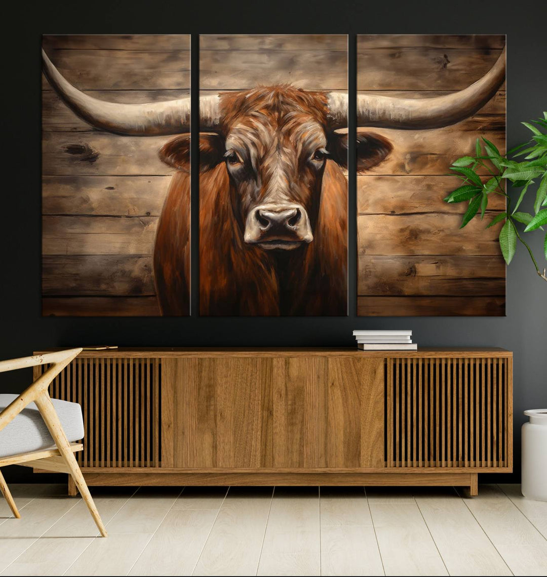 The Longhorn Bull Wall Art, a ready-to-hang canvas print, showcases an image of a brown longhorn cow set against a wooden background, perfect for those looking to enhance their space with rustic farmhouse and western barn decor.