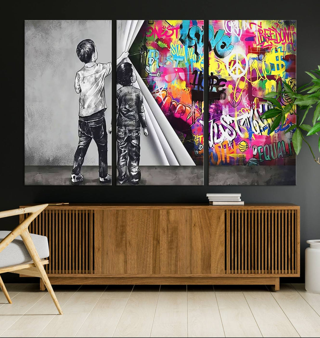 The Banksy Print - Street Art Canvas features a vibrant and bold image of two children lifting a curtain to reveal colorful graffiti. It's ready to hang, adding an urban modern decor vibe.