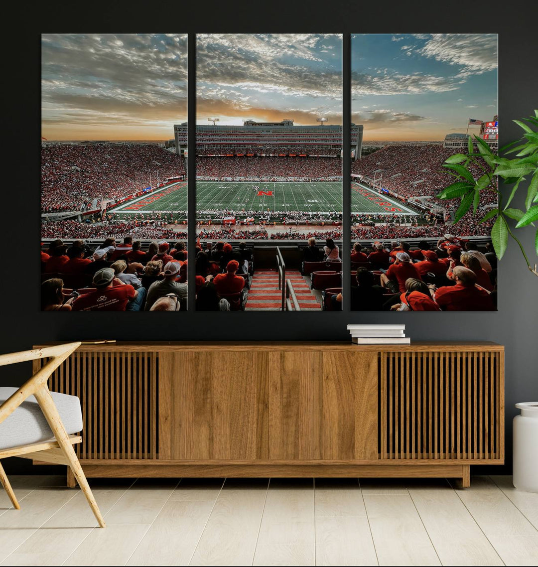 The living room features a stunning triptych of Lincoln Memorial Stadium wall art canvas print, celebrating the University of Nebraska Cornhuskers football team. This piece serves as captivating wall art, showcasing a gallery-quality finish.