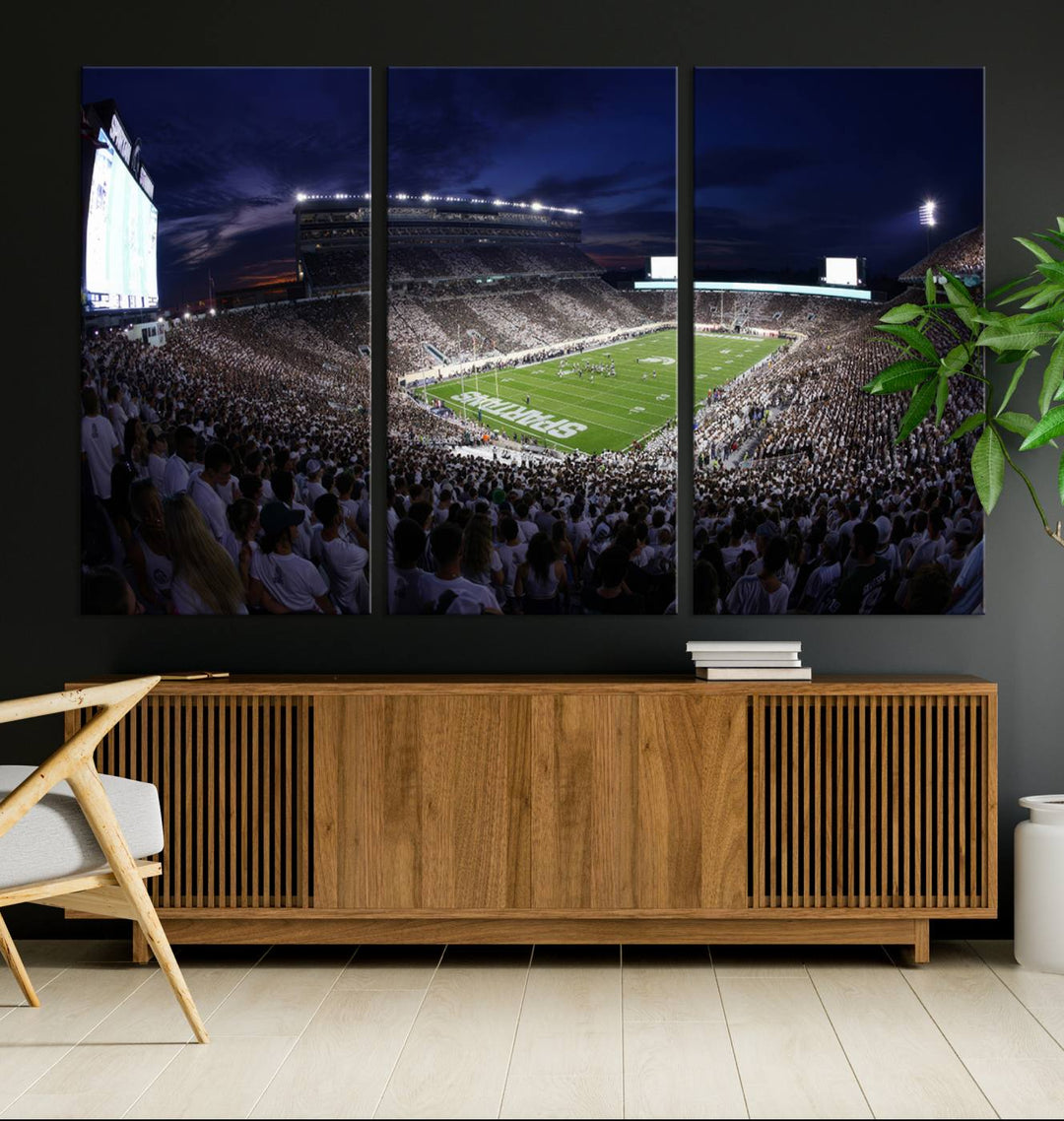 A packed football stadium at night, with bright lights and fans in white, depicted in a Michigan State Spartans Stadium wall art.