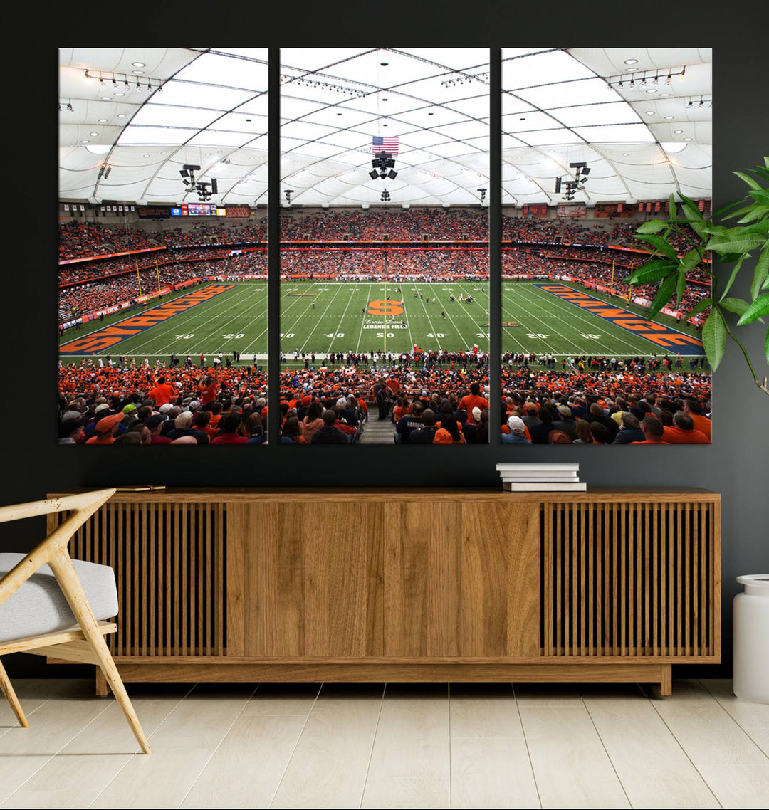 Fans fill the Syracuse JMA Wireless Dome, highlighted in orange and blue under a vaulted roof on this premium canvas print of the scene.