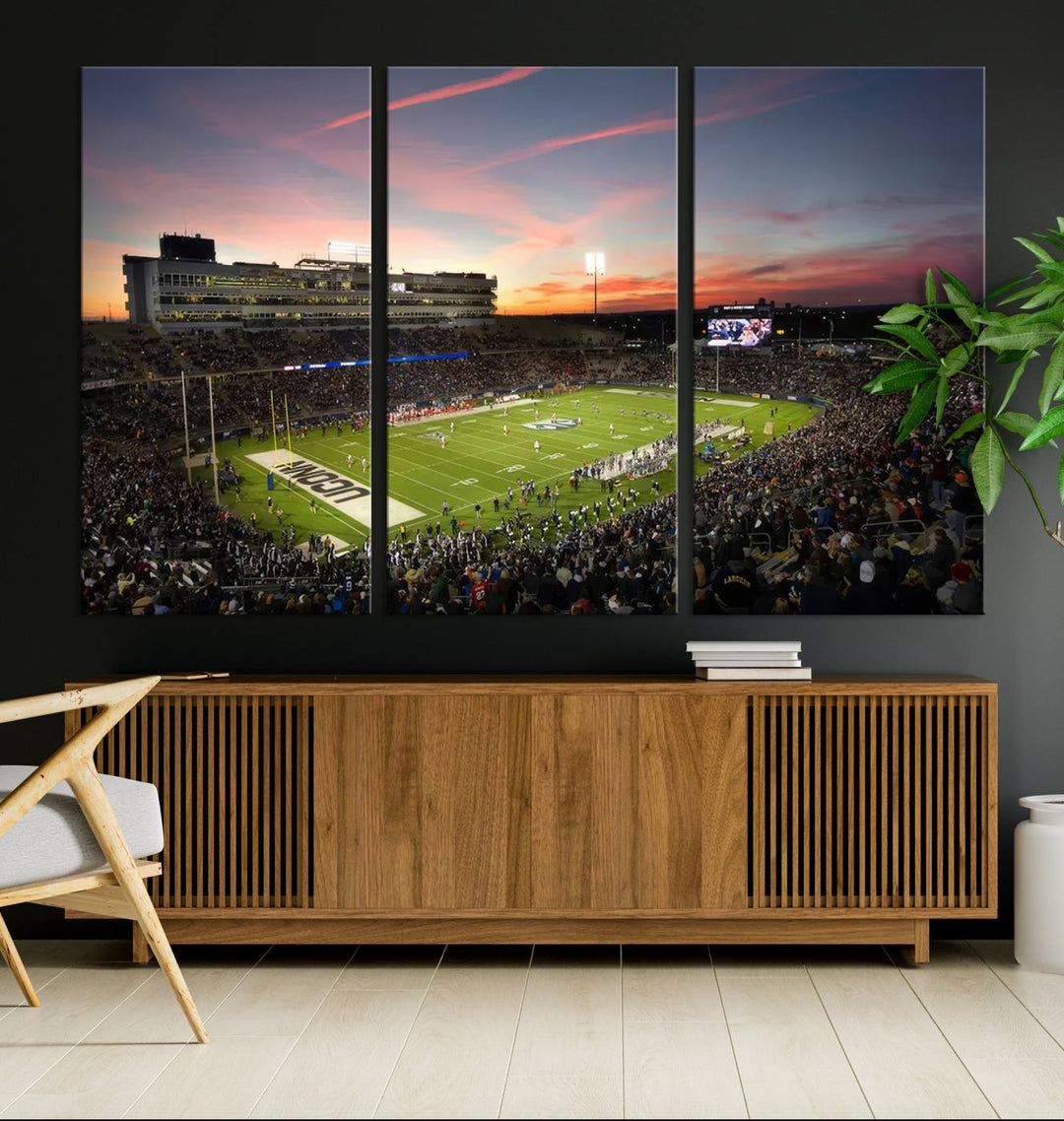 This wall art canvas print captures UCONN Huskies fans energizing a sunset scene at East Hartfords Pratt & Whitney Stadium.