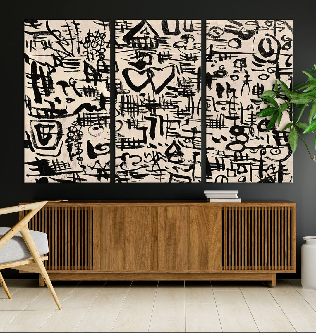 The Abstract Love and Chaos canvas is a museum-quality print featuring black symbols on a beige background, adorned with a heart and scribble design. It is framed to enhance its artistic appeal.