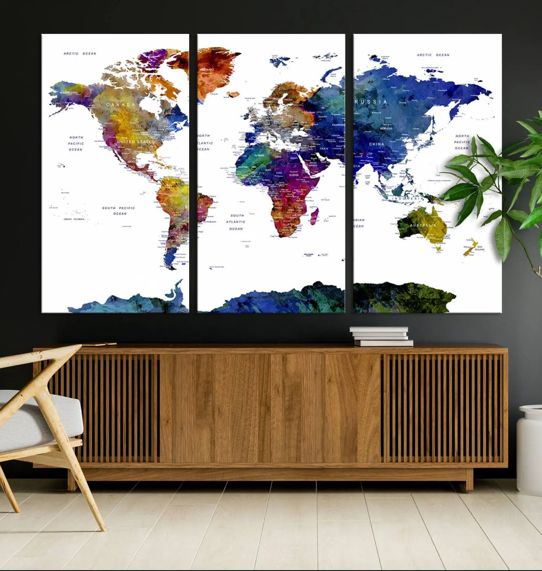 A Colorful World Map Canvas Art Print, with its vivid hues, is elegantly displayed against the dark wall.