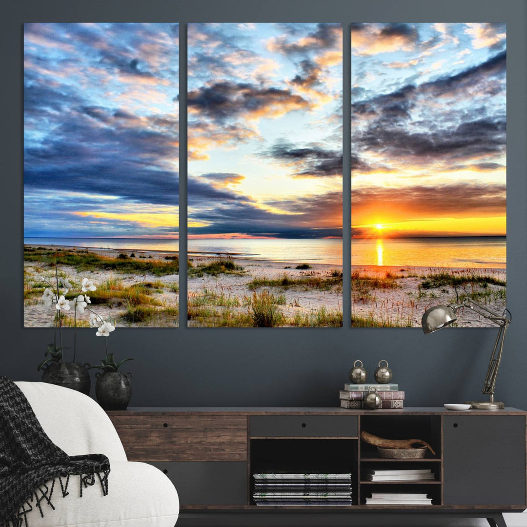 The Sunset On The Ocean canvas wall art features a beautiful beach sunset with grass and clouds.