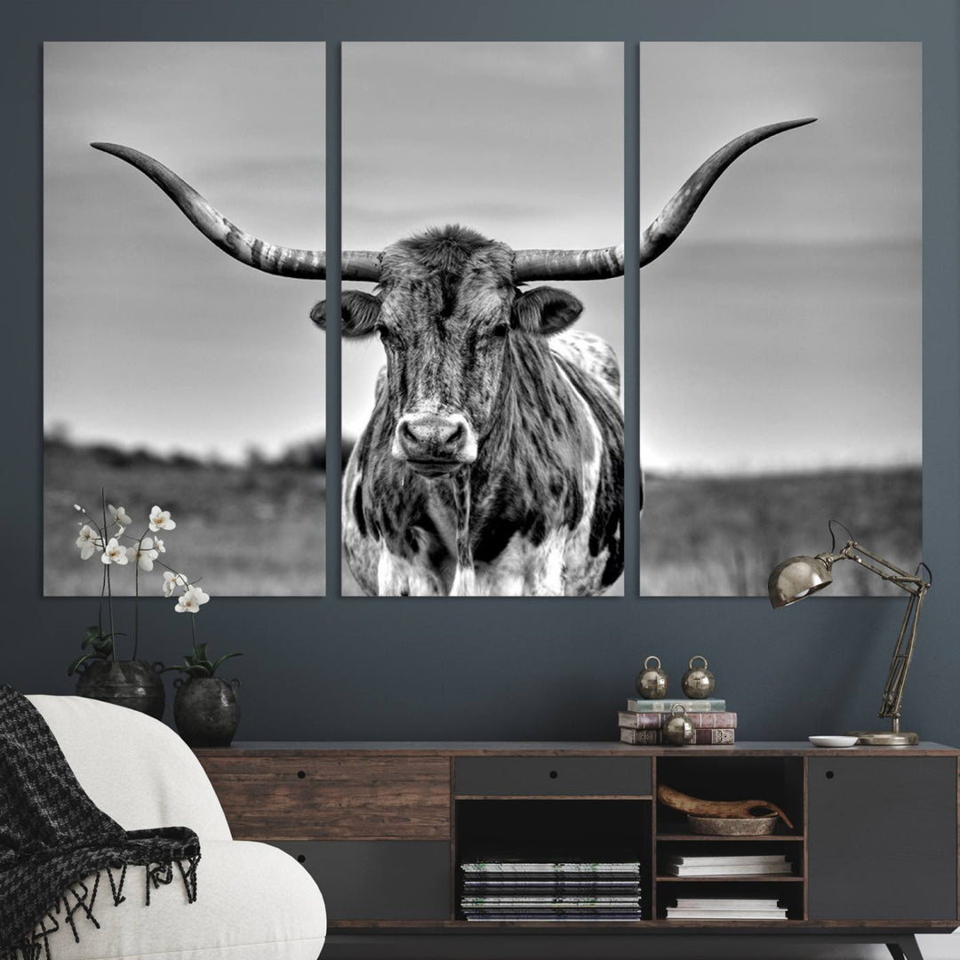 The Texas Longhorn Cow wall art, divided into three panels, is of gallery quality and displayed on a dark wall.