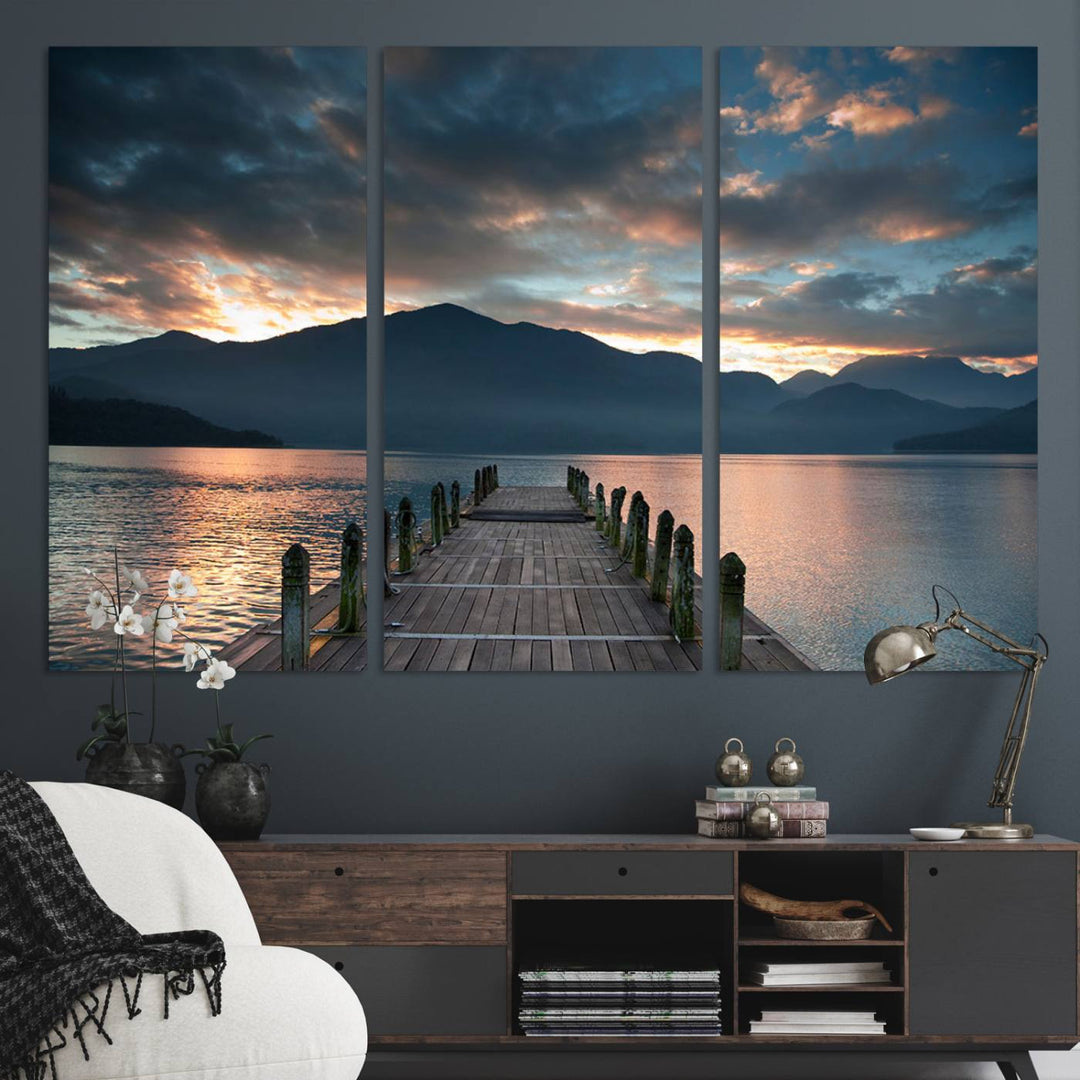 The Mountain Lake Wood Pier Canvas Wall Art depicts a serene lake and mountains, enhancing the beauty of any space.