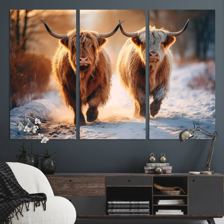 The wall art is a Scottish Highland Cow Horn canvas print featuring cows on a snowy path bathed in warm sunlight, serving as a rustic decor piece.