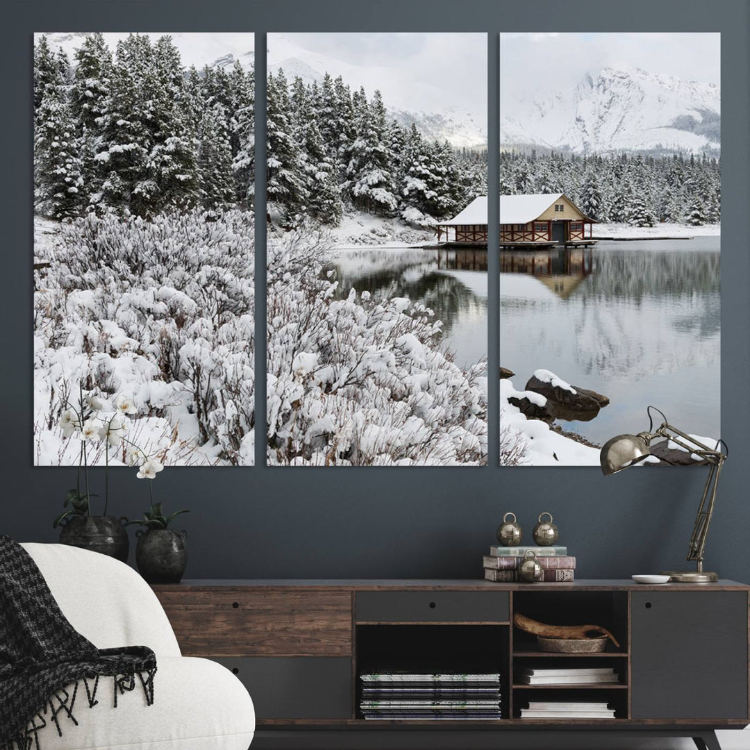 Experience the beauty of winter with the "Cabin by the Lake Canvas Wall Art," showcasing a serene snowy landscape. This rustic nature decor features a cozy cabin nestled amid snow-laden trees, set against a breathtaking mountain view, perfect for enhancing your living room.