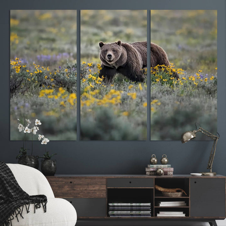 The "Grizzly 399 in Wild Flowers Wall Art Canvas Print" features a grizzly bear strolling through a field of yellow and purple flowers, beautifully showcased as a triptych. This handcrafted piece, proudly made in the USA, adds charm and sophistication to your space.