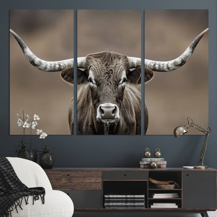 A close-up of a longhorn bull facing forward is featured in the Framed Texas Test-1, set against a blurred brown background.