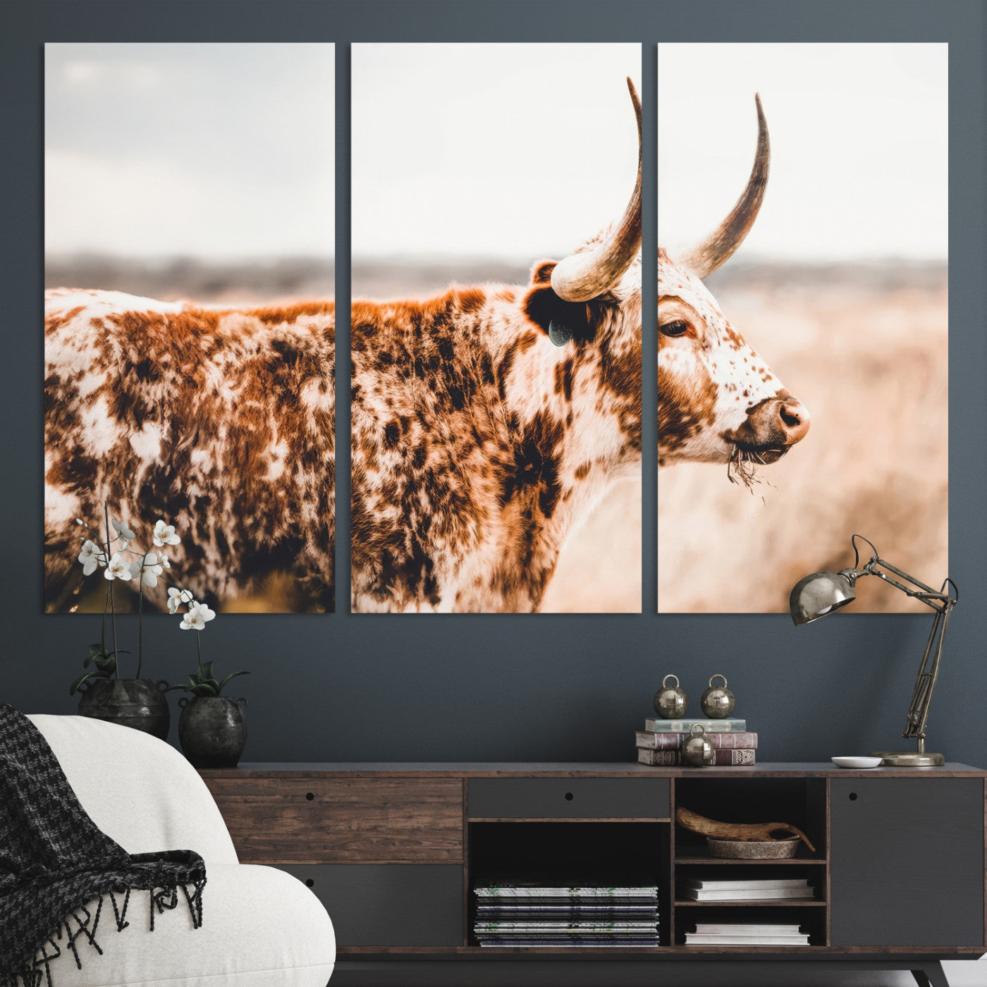 Speckled Texas longhorn with curved horns standing in a warm-toned prairie, perfect for rustic or country-style home decor.