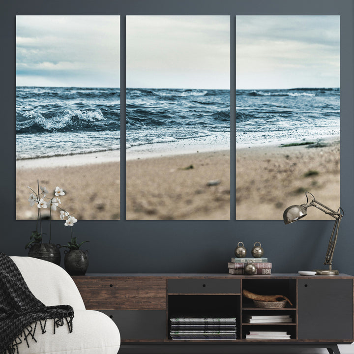 A moody ocean scene with gentle waves washing onto a sandy beach under a cloudy sky, creating a peaceful and coastal atmosphere.